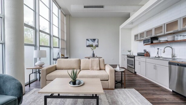 A modern kitchen with white cabinetry, a stainless steel refrigerator, and a built-in oven. - Landing | Stylish 1BD, Courtyard (Kansas City)