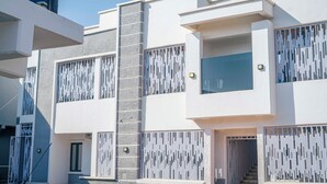 A modern building with a central staircase, multiple balconies, and a patterned facade. - The Rock Aparthotel (Zaria)