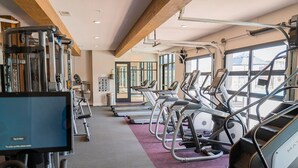 Ein Fitnessstudio mit Laufbändern, Crosstrainern und Kraftgeräten.