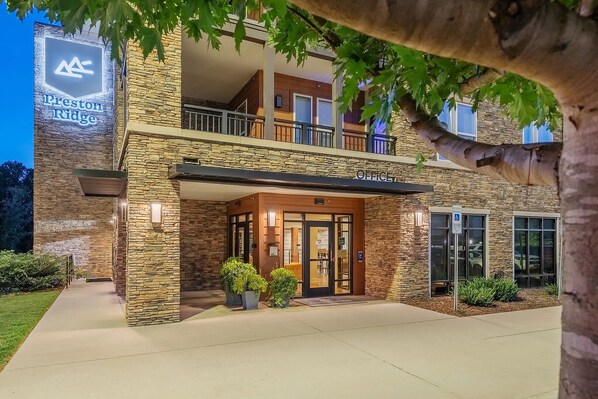 A two-story building with a stone facade, a balcony, and a sign indicating 'Preston Ridge.' - Landing | Chic 2BD, Gym, Clubhouse (Hickory)