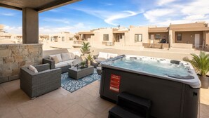 A rooftop patio with outdoor furniture, a hot tub, and a stone wall. - Private Balcony Hot Tub | Pool | Near Golf Course (Washington)