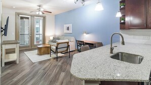 A modern kitchen with granite countertops, a built-in sink, and a dining area with a table and chairs. - Landing | Stylish 1BD, Clubhouse, Gym (Houston)