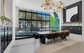 Ein moderner Essbereich mit großem Tisch, Stühlen und Blick durch große Fenster.