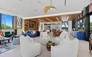 Eine großzügige Lobby mit modernen Möbeln, einem Essbereich und großen Fenstern mit Blick auf die Stadt.
