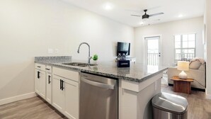 Una cucina moderna con un piano di lavoro in granito, elettrodomestici in acciaio inossidabile e lavastoviglie integrata.