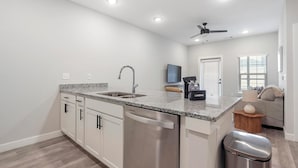 A modern kitchen with granite countertops, stainless steel appliances, and a built-in dishwasher. - Landing | Stunning 1BD in Shell Point (Port Royal)