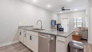 A modern kitchen with granite countertops, stainless steel appliances, and a built-in dishwasher. - Landing | Incredible 1BD, Gym (Port Royal)