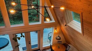 Un espacio tipo loft con techo alto, amplias ventanas, comedor y una zona de estar acogedora.