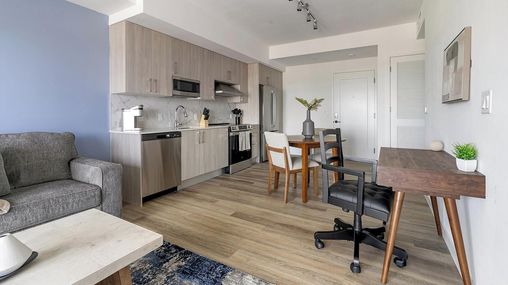 A modern apartment with a kitchen, dining area, and living room.
