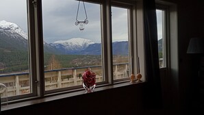 A room with a window overlooking a mountainous landscape.