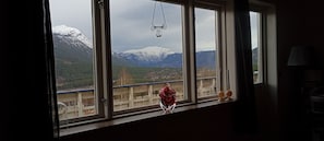Une pièce avec une fenêtre donnant sur un paysage montagneux.