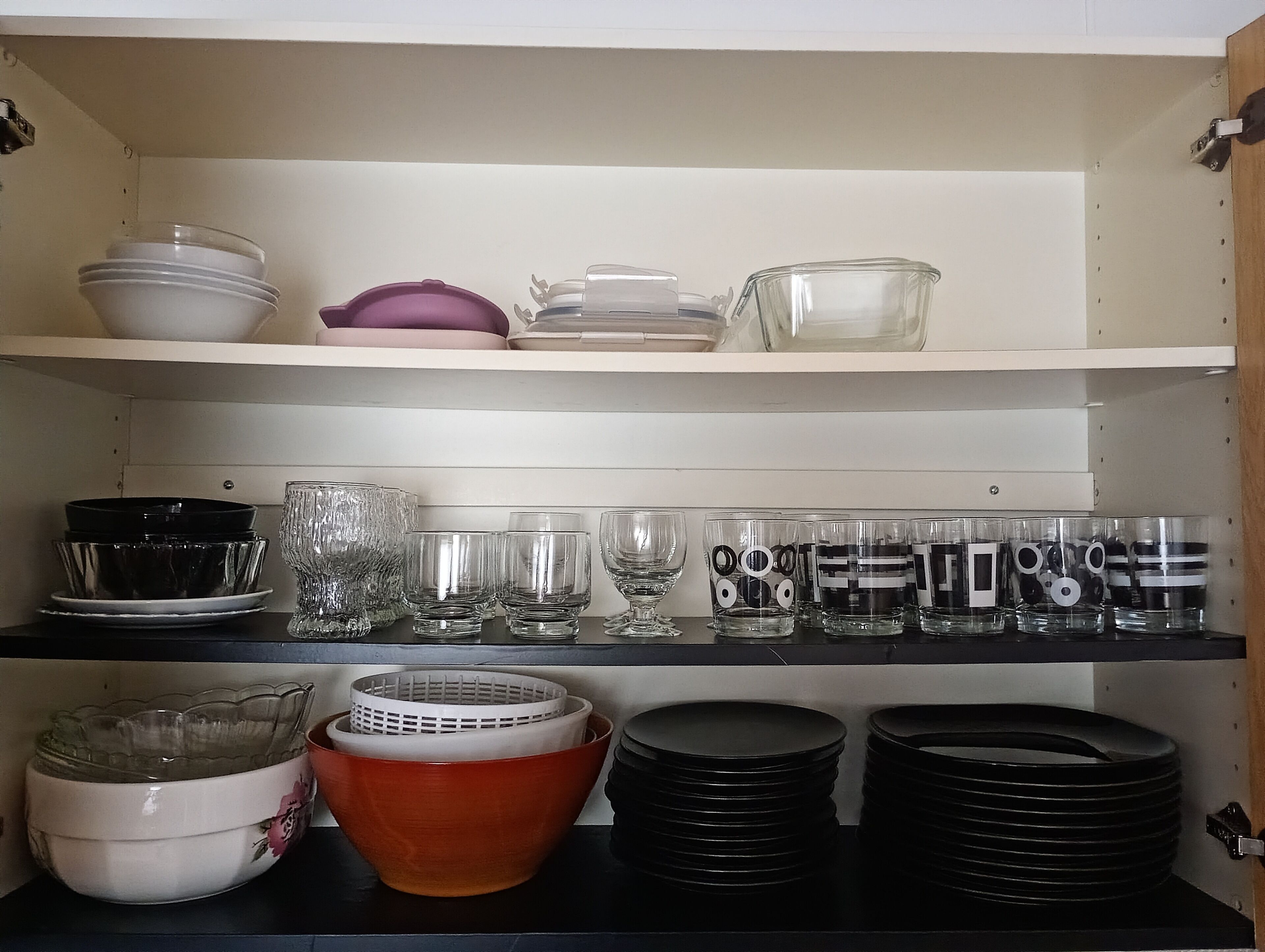 Una repisa de cocina con diferentes platos y cristalería.