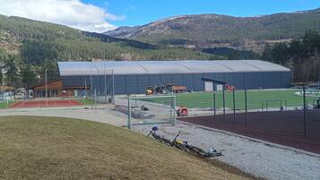 A sports facility with a large building, a running track, and a field.