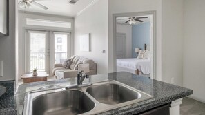 A modern bathroom with a double sink, a mirror, and a ceiling fan. - Landing | Stunning 2BD, Clubhouse, Game Room (Houston)