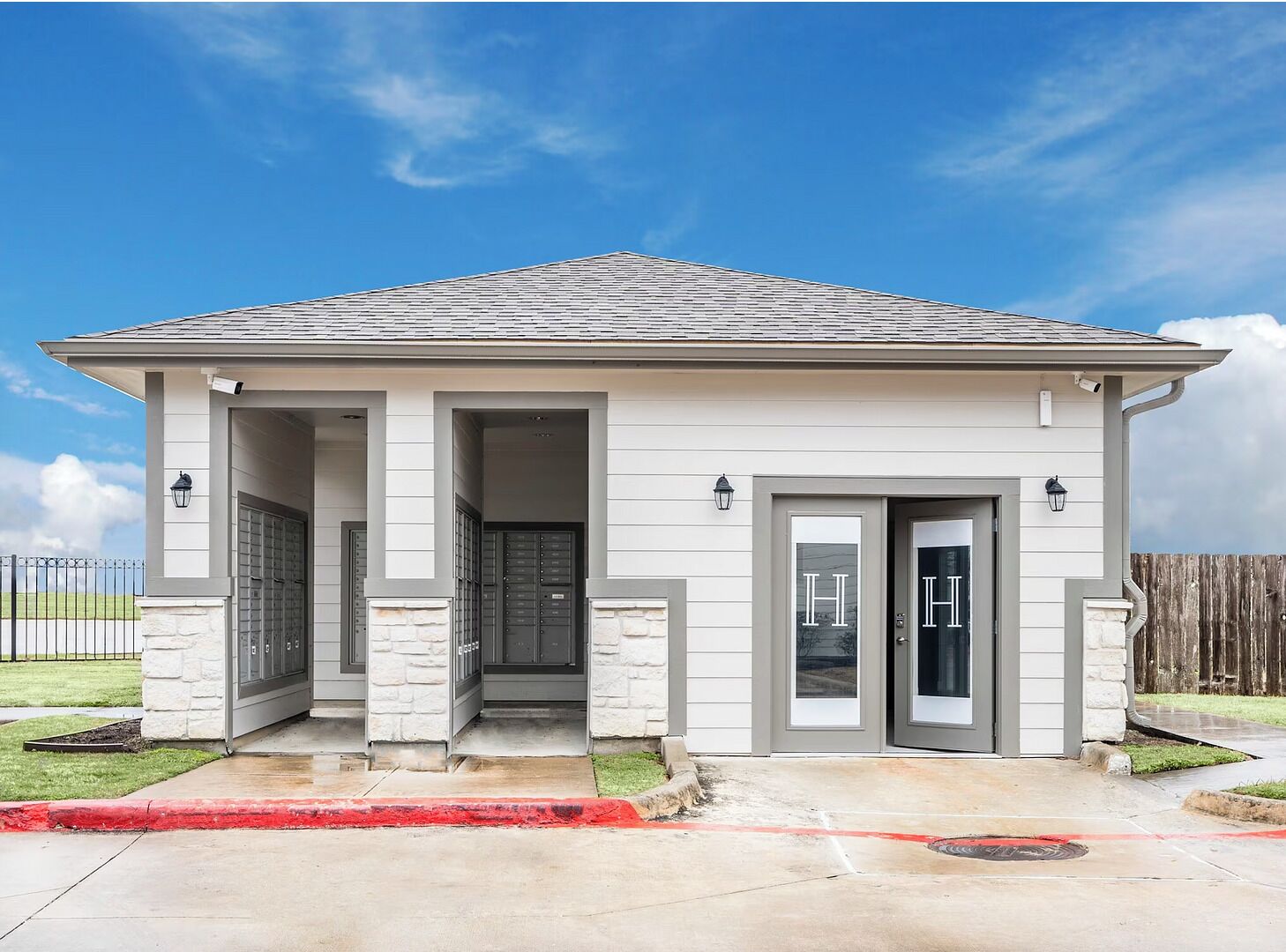 A single-story house with a gabled roof, a front porch with columns, and a garage door.