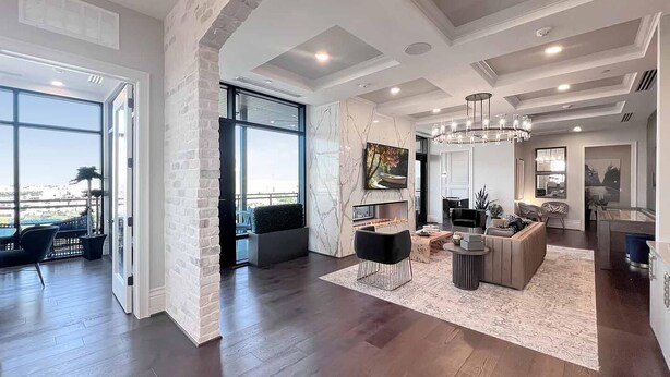 A spacious living area with a fireplace, modern furniture, and large windows offering a view. - Landing | Stylish Studio, Gym, Clubhouse (Houston)