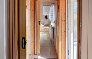 A hallway with wooden doors, a tiled floor, and a view into a room with a sink and chair. - 1 bedroom gorgeous home in Waren (Waren)