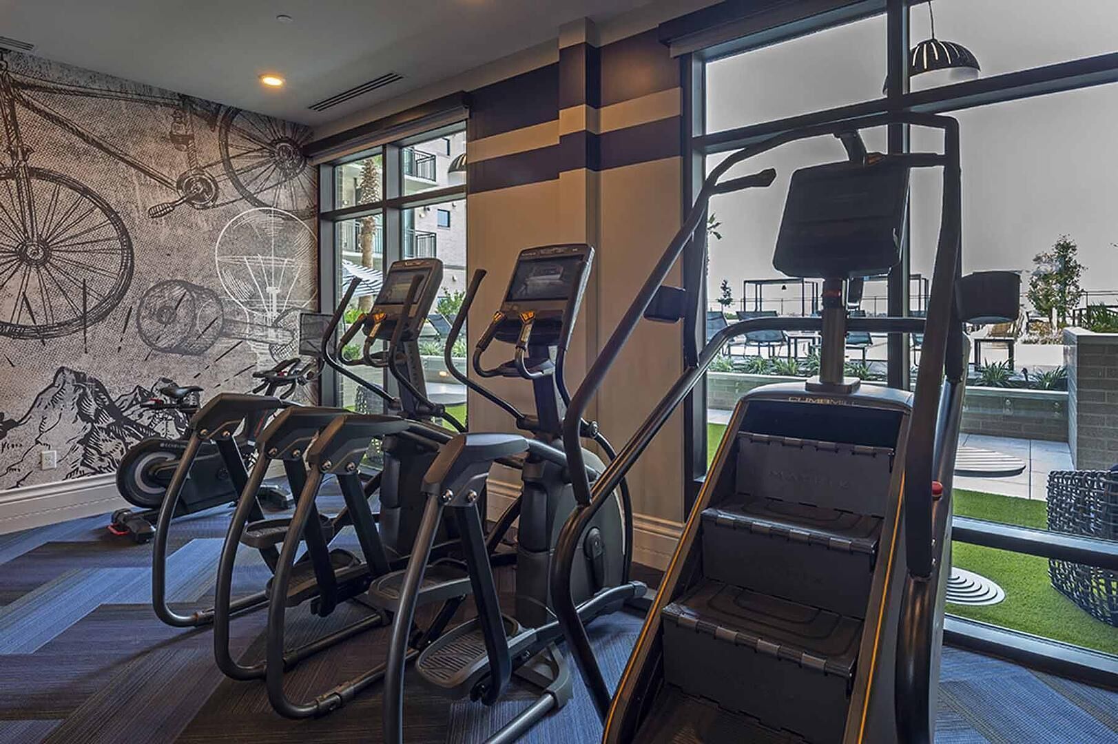 Un gimnasio con bicicletas estáticas, cintas de correr y una máquina de pesas.
