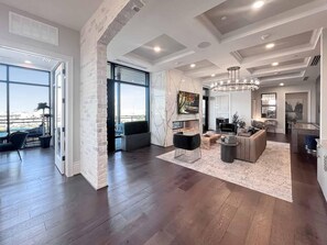 Amplia sala de estar con chimenea, muebles modernos y ventanas grandes que ofrecen una vista.