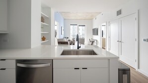 Cocina moderna con isla central, electrodomésticos integrados y vistas al área de estar.