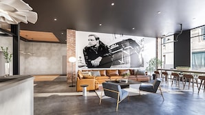 Een modern interieur met een grote muurschildering, leren banken en een bar.