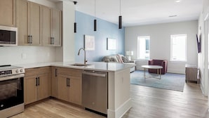 Een moderne keuken met houten kastjes, een vaatwasser en een inbouwoven.