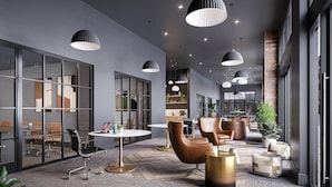 Een modern interieur met glazen scheidingswanden, lederen stoelen, ronde tafels en hanglampen.
