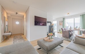 Una sala de estar moderna con chimenea, zona de estar y vistas al exterior.