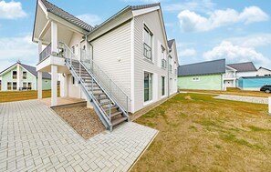 A two-story house with a covered porch, a staircase, and a paved driveway. - 2 bedroom lovely apartment in Olpenitz (Olpenitz)