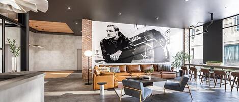 A modern interior with a large mural, leather sofas, and a bar area.