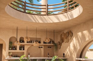 A circular bar area with a wooden railing, pendant lights, and shelves with bottles. - Casa Joseph Troncones - Adults Only (Troncones)