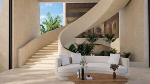 A modern interior with a curved staircase, a white sofa, and a coffee table.