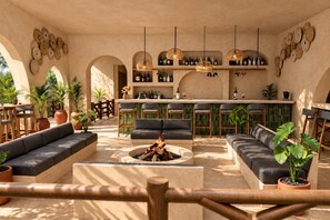 A spacious lounge area with a bar, seating arrangements, and a fire pit. - Casa Joseph Troncones - Adults Only (Troncones)