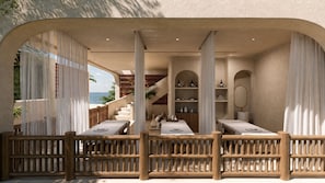 Un área de spa con barandillas de madera, una escalera y vista al océano.