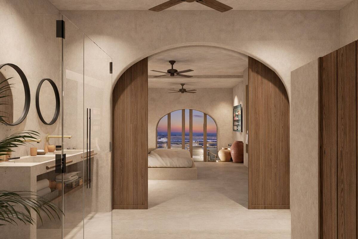 A modern bedroom with a large arched window, a ceiling fan, and a view of the ocean.