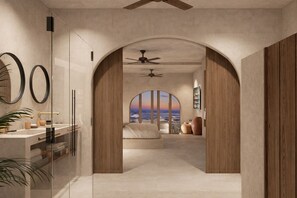 Un dormitorio moderno con un amplio ventanal arqueado, un ventilador de techo y vistas al océano.