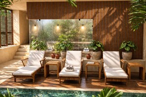 A poolside area with lounge chairs and potted plants.