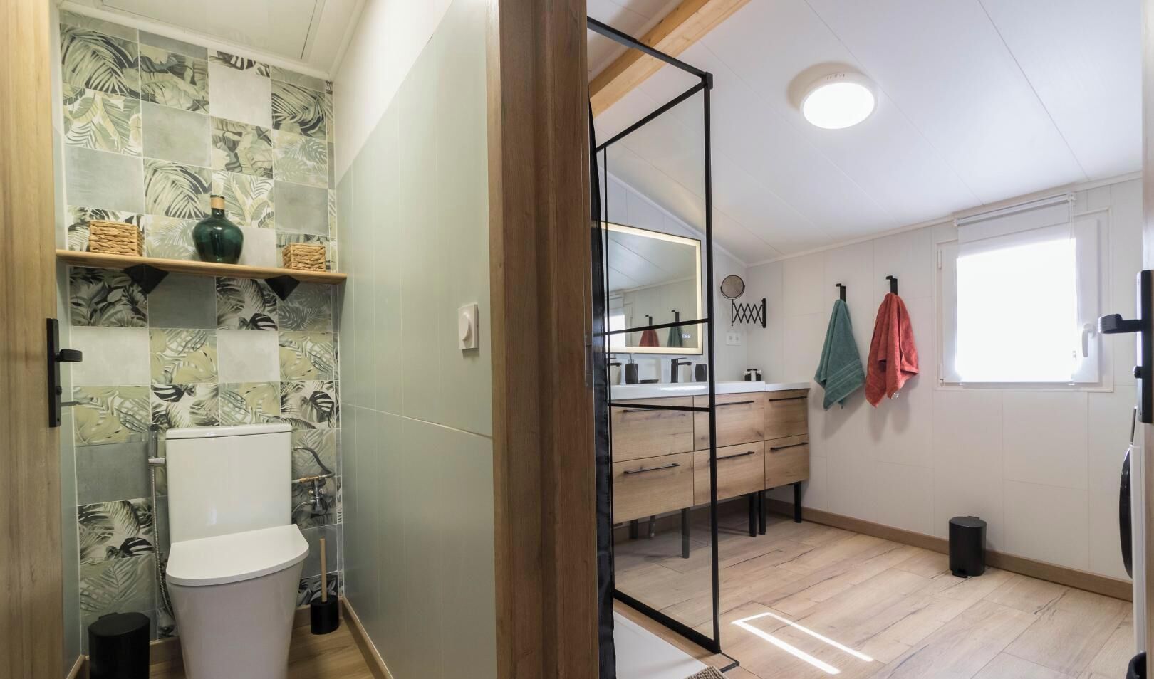 Un baño con ducha, inodoro y tocador con espejo.