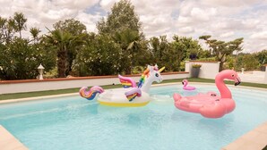 Ein Swimmingpool mit aufblasbaren Einhorn- und Flamingopflänzchen.