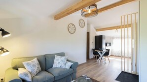 Ein Wohnzimmer mit einer Couch, einem Couchtisch und einem Essbereich mit Tisch und Stühlen.