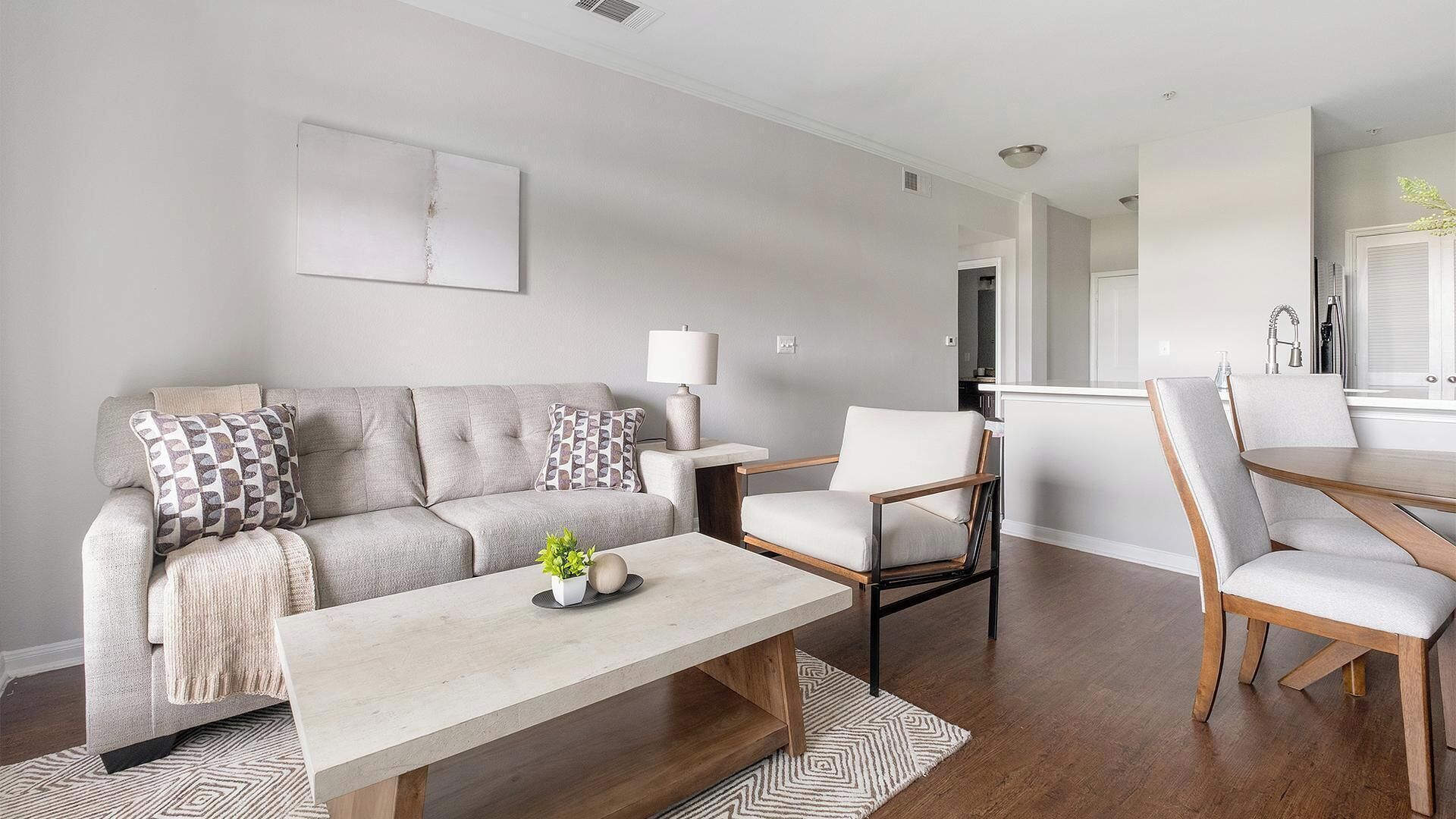 A modern living room with a sofa, coffee table, and chairs.