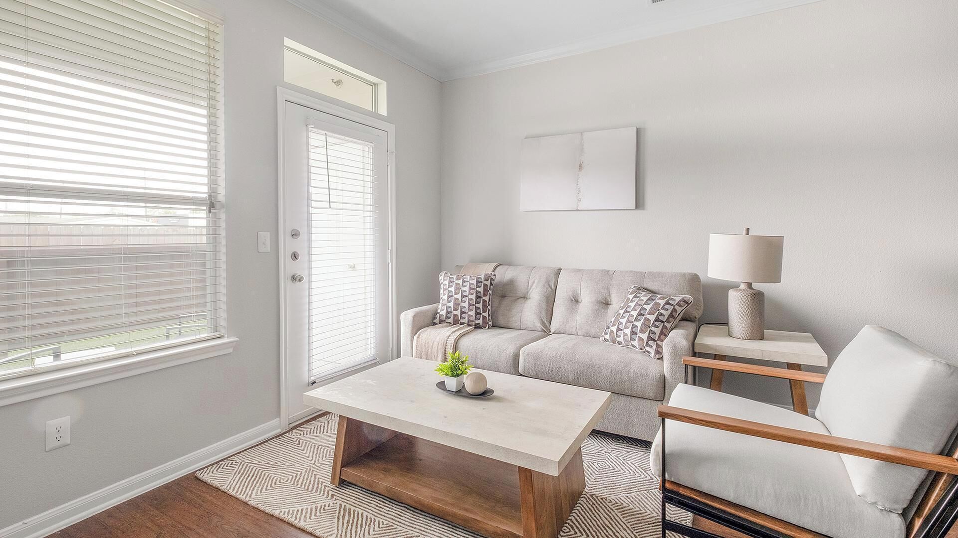 A living room with a sofa, coffee table, and a lamp.