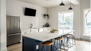 A modern kitchen with a built-in island, stainless steel appliances, and pendant lighting. - Landing | Stylish 2BD, Game Room, Clubhouse (Houston)