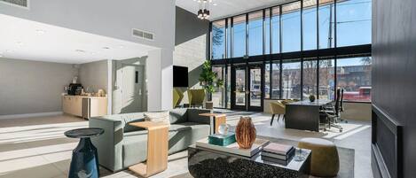 Ein modernes Interieur mit einer Sitzecke, einer Küche und großen Fenstern.