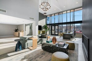 Ein modernes Interieur mit einer Sitzecke, einer Küche und großen Fenstern.