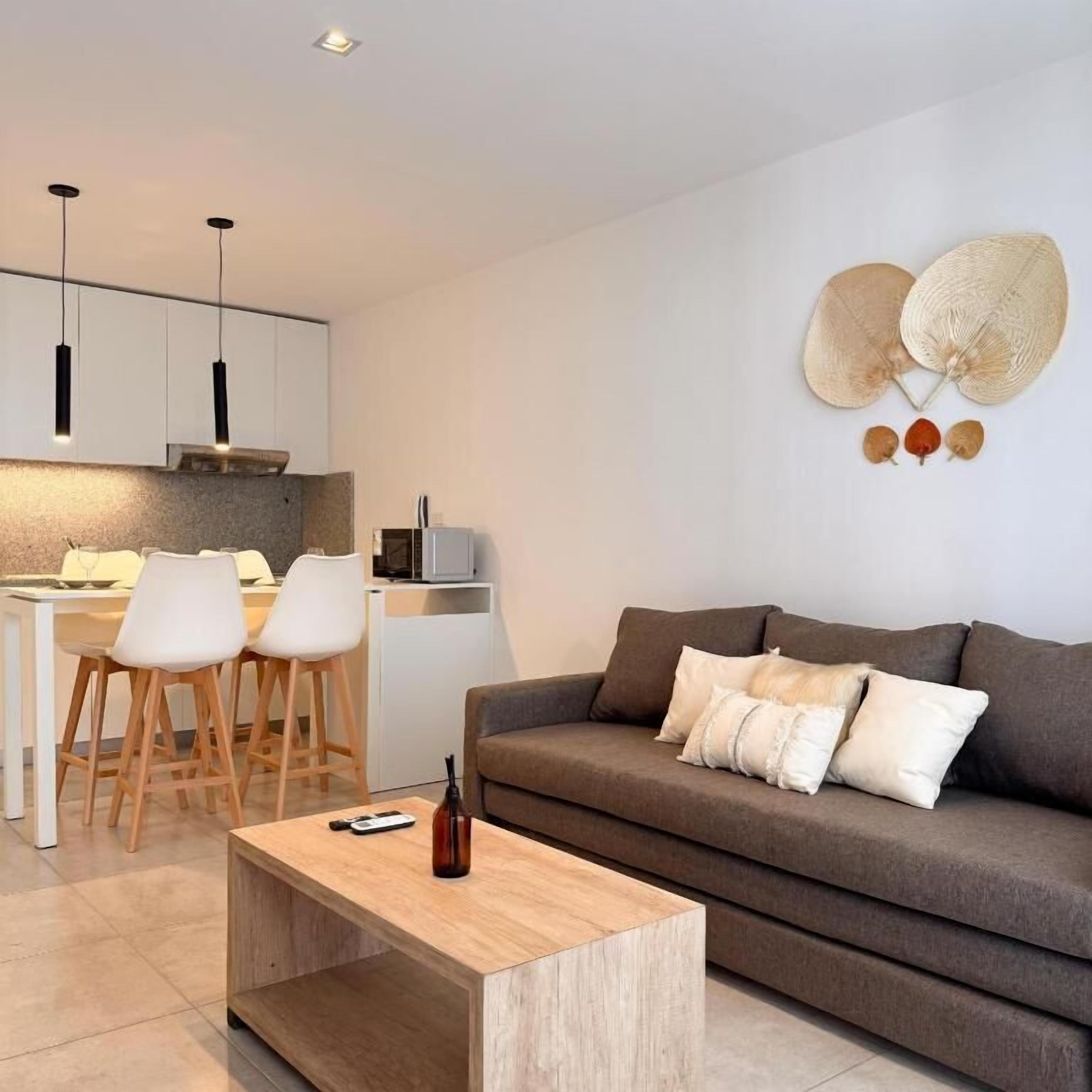 Una sala de estar moderna con un sofá, una mesa de centro y un comedor con sillas y una mesa.