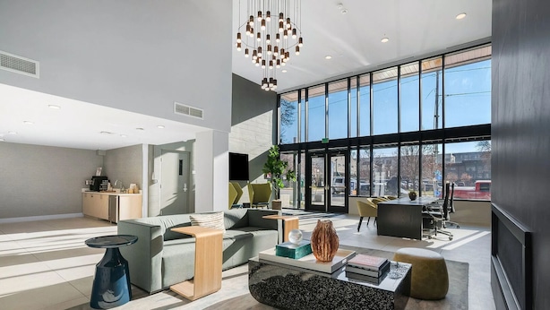 A modern interior with a seating area, a kitchen, and large windows. - Landing | Chic 1BD in Central City (Salt Lake City)