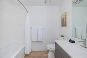 Un baño moderno con bañera, inodoro y lavamanos.