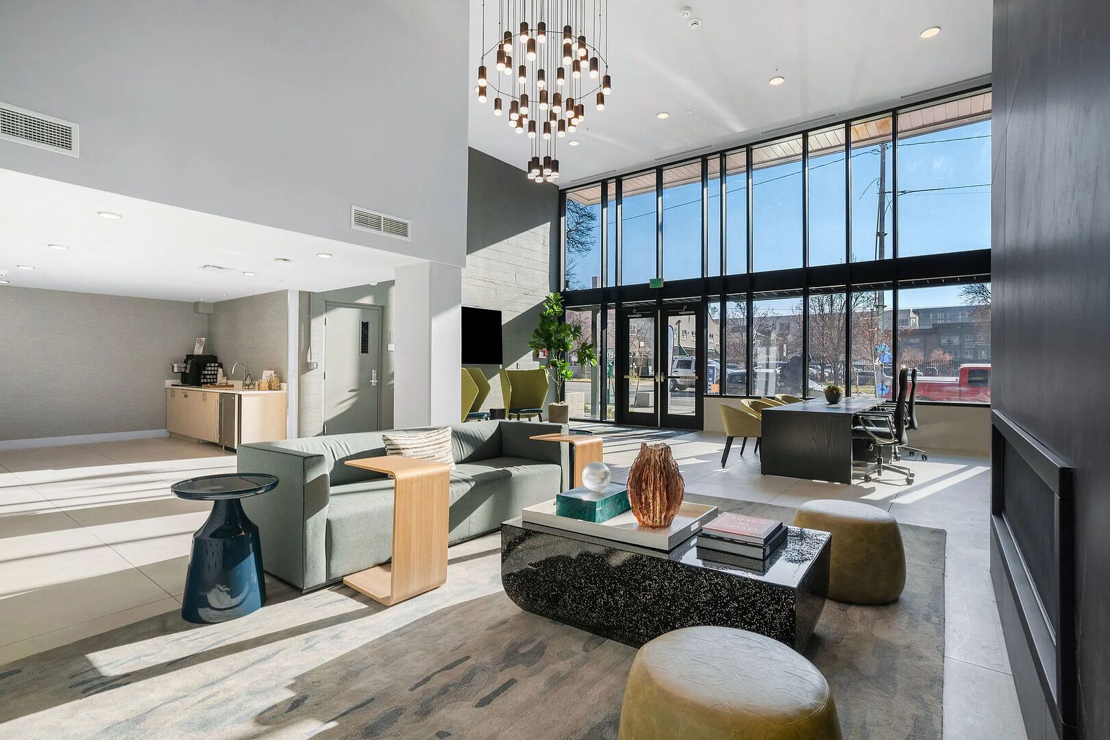 Ein modernes Interieur mit einer Sitzecke, einer Küche und großen Fenstern.