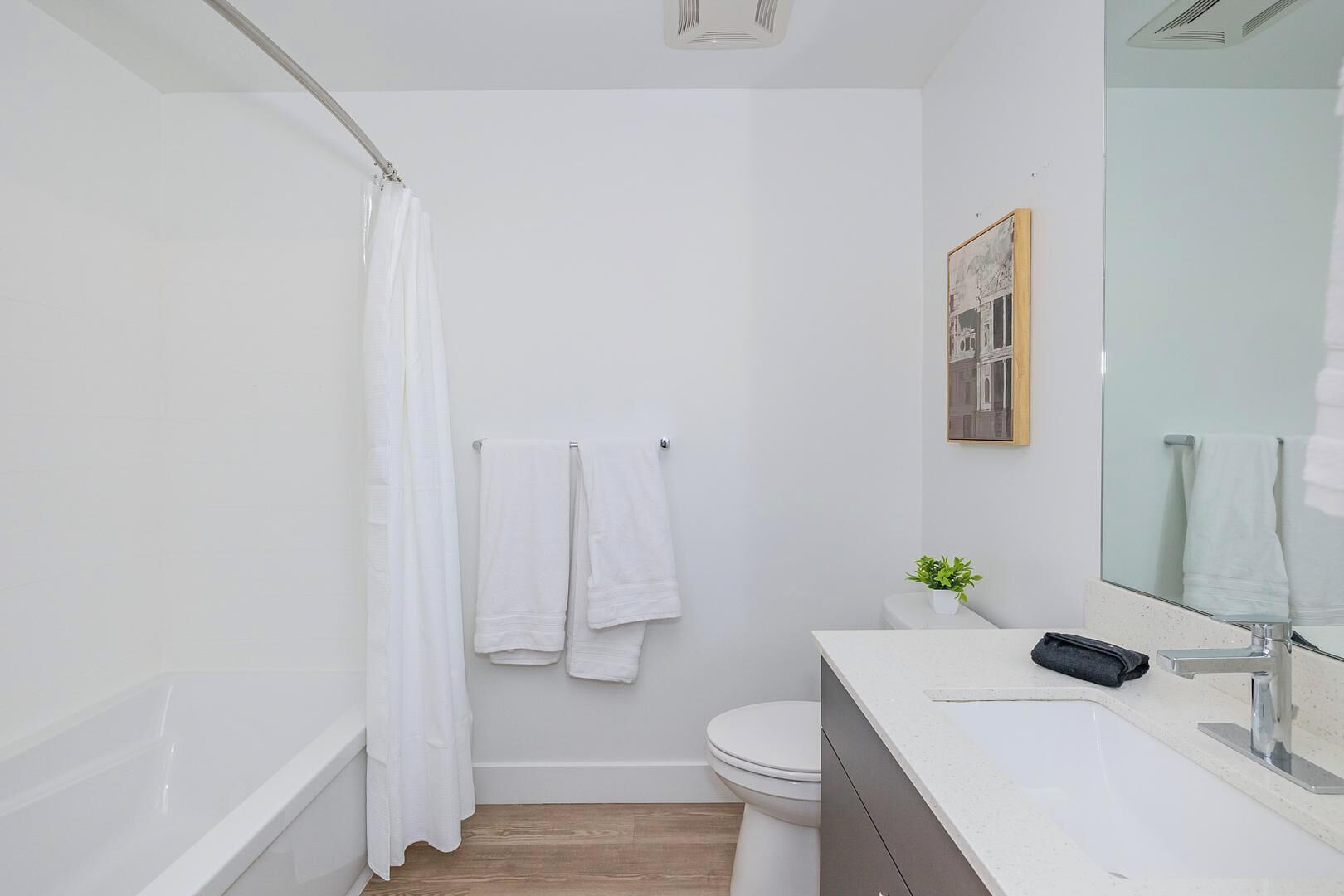 A modern bathroom with a shower, toilet, and sink.